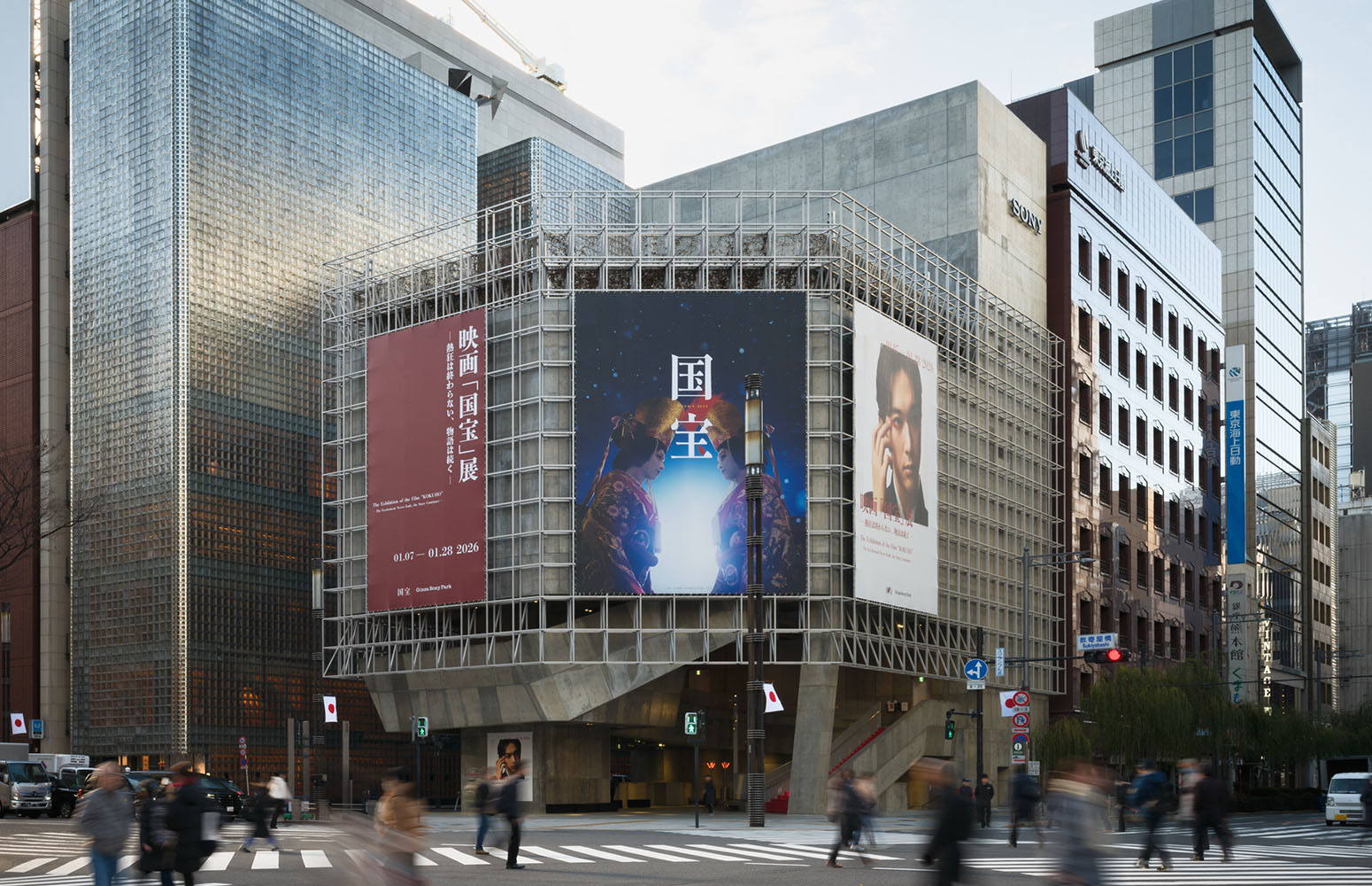 Exterior view of Ginza Sony Park at the Sukiyabashi intersection, featuring large banners for the film “KOKUHO,” with pedestrians crossing in front of the building.